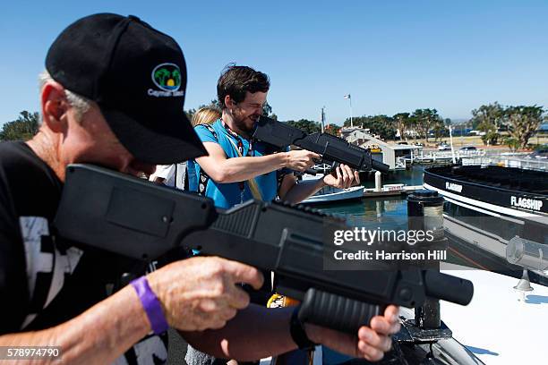 Attendees shoot at zombies during a Walking Dead attraction on board of the Abigail during the second day of Comic Con in San Diego, CA.