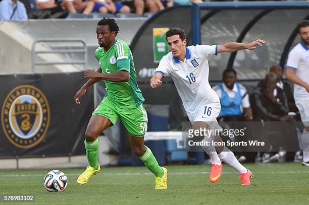 Nigerian national football team Efe Ambrose carries the ball past Greek national football team Lazaros Christodoulopoulos during a International...