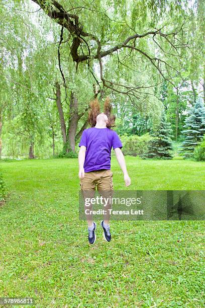 teen boy jumping - teen boy shorts stockfoto's en -beelden