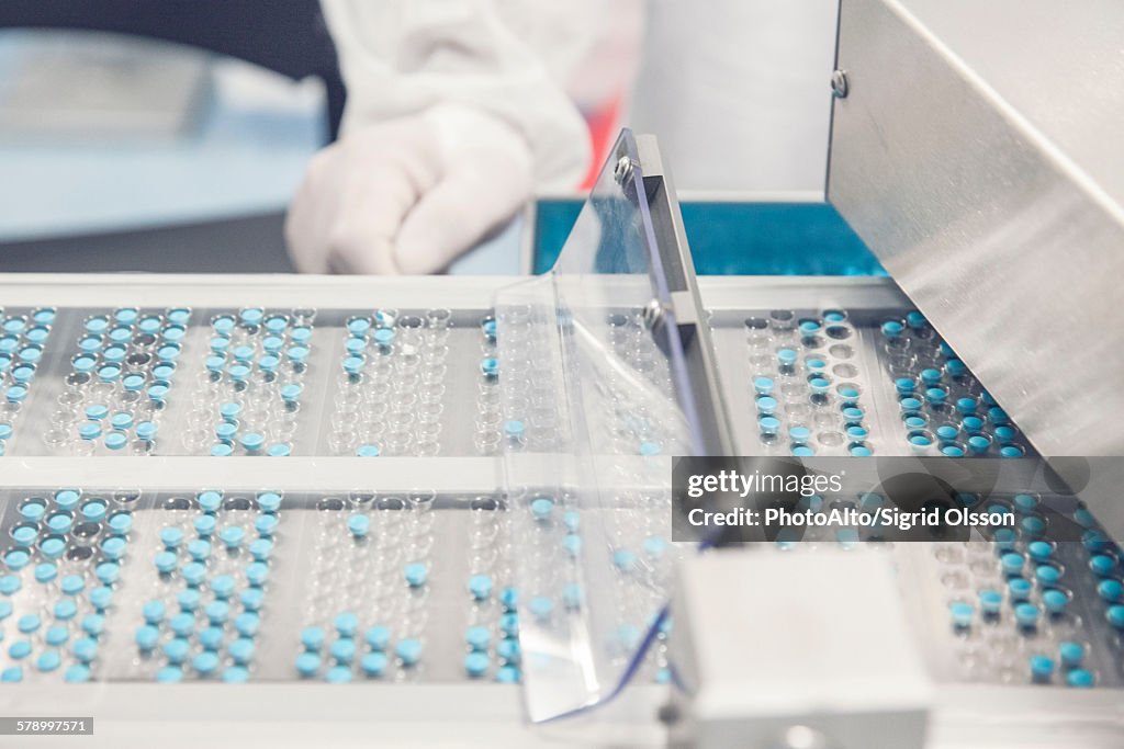 Tablet trays passing into prescription drug packaging equipment