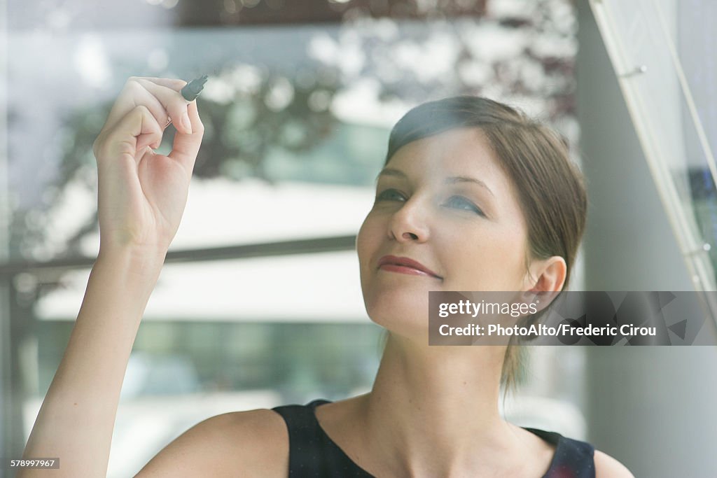 Woman preparing to write on window with marker