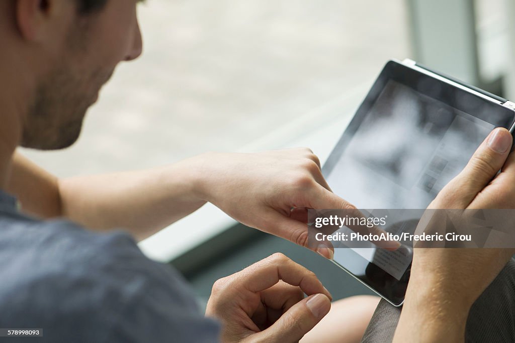 Couple using digital tablet together, cropped