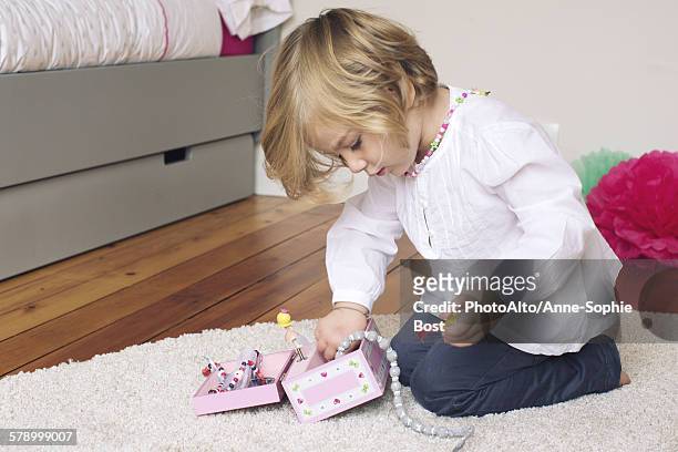 little girl removing necklace from jewellery box - costume jewelry fotografías e imágenes de stock