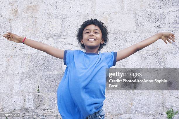 boy standing with his arms outstretched, eyes closed, portrait - child boy arms out stock pictures, royalty-free photos & images