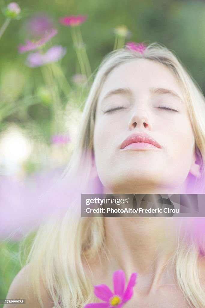 Woman overwhelmed by the sweet fragrence of blooming flowers