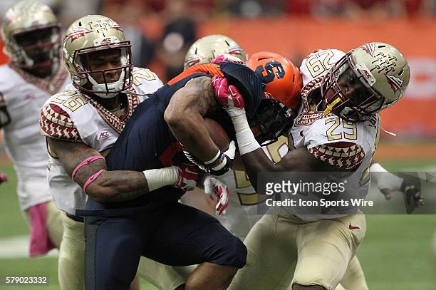 Florida State Seminoles defensive back P.J. Williams and defensive back Nate Andrews wrap up Syracuse Orange running back Prince-Tyson Gulley during...