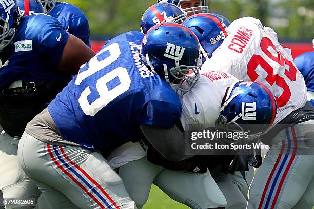 New York Giants running back David Wilson gets tackled by New York Giants defensive tackle Cullen Jenkins during training camp at the Timex...