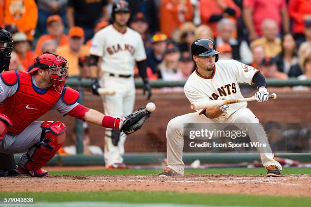 San Francisco Giants left fielder Juan Perez tries to bunt as St. Louis Cardinals catcher A.J. Pierzynski bobbles the ball, during game 3 of the...