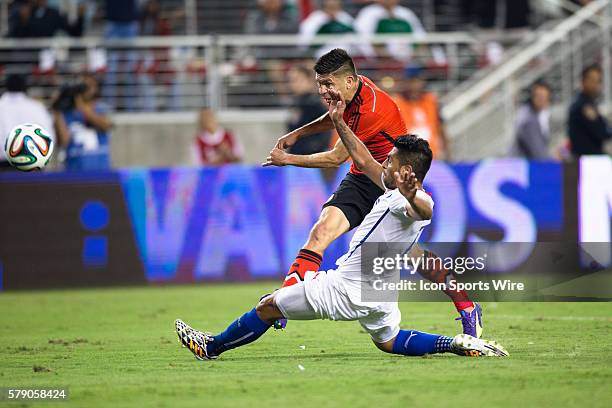 Mexico forward Oribe Peralta tries a shot on goal but is blocked by Chile defender Gonzalo Jara , during the game between Mexico and Chile at Levi's...