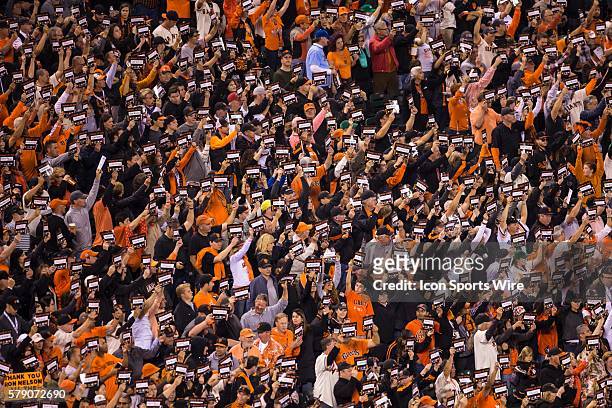 Fans stand and hold signs in support of cancer research, during game three of the World Series between the San Francisco Giants and the Kansas City...