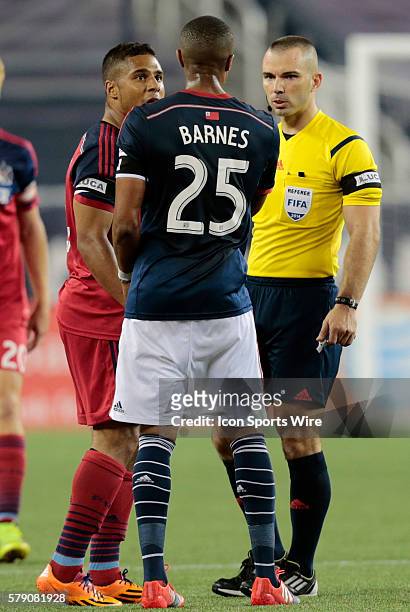 Referee Chris Penso listens to both sides from Chicago Fire's Quincy Amarikwa and New England Revolution's Darrius Barnes . The New England...