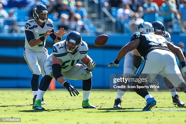 Seattle Seahawks guard Stephen Schilling snaps the ball back to a shotgun positioned quarterback Russell Wilson with guard J.R. Sweezy dropping back...