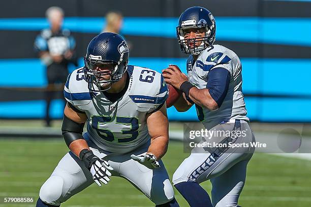 Seattle Seahawks quarterback Russell Wilson takes practice snaps from guard Stephen Schilling during warm ups before the game between the Seattle...