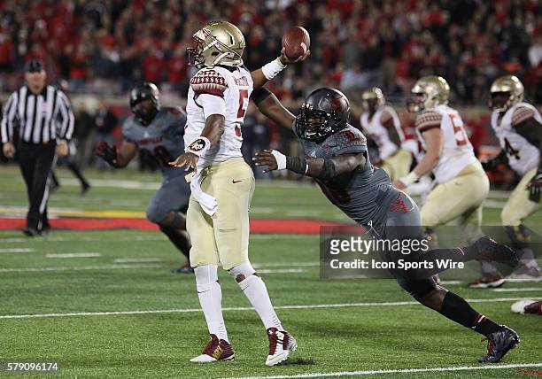 Florida State Seminoles quarterback Jameis Winston is pursued by Louisville Cardinals defensive end Deiontrez Mount in a game between the Florida...