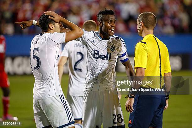 Vancouver FC midfielder Gershon Koffie and midfielder Matias Laba argue with referee Mark Geiger about a hand ball call during the MLS Western...