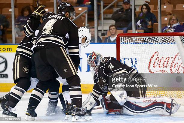 Hershey Bears' Philipp Grubauer covers the puck as Manchester Monarch's Josh Gratton is smothered by Hershey Bears' Jon Landry and Hershey Bears'...