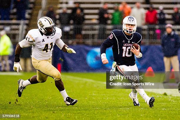 Uconn Huskies Quarterback Chandler Whitmer runs the ball down field during an American Athletic Conference football game between the University of...