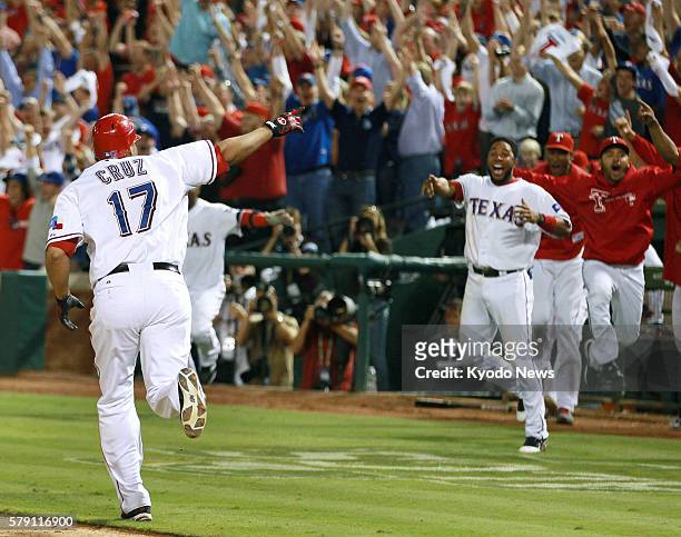 United States - Texas Rangers right fielder Nelson Cruz celebrates with his teammates after blasting the first walk-off grand slam in postseason...