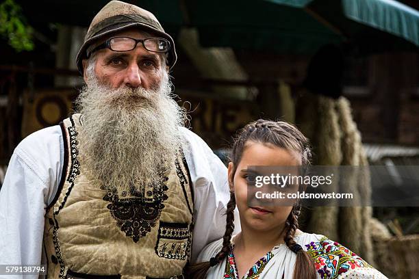 leather maker and his daughter in traditional clothing, bucharest, romania - romania village stock pictures, royalty-free photos & images