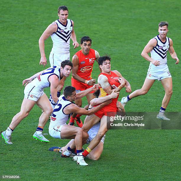 Jesse Lonergan of the Suns is tackled during the round 18 AFL match between the Gold Coast Suns and the Fremantle Dockers at Metricon Stadium on July...