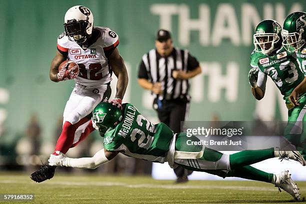 Nic Grigsby of the Ottawa Redblacks avoids the tackle of Brandon McDonald of the Saskatchewan Roughriders in the game between the Ottawa Redblacks...