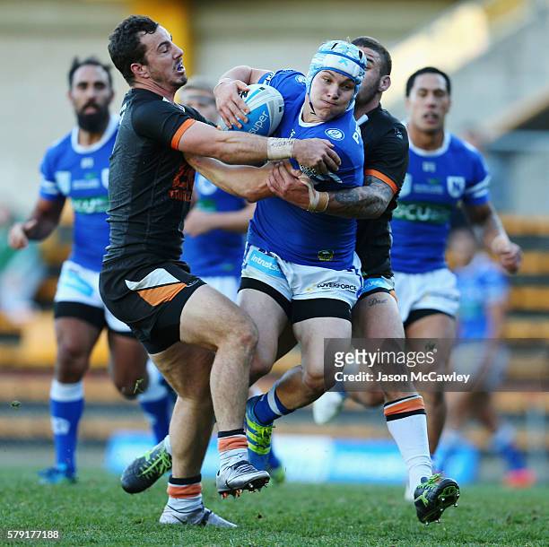 Joshua Cleeland of the Newtown Jets is tackled during the round 19 Intrust Super Premiership NSW match between the Wests Tigers and the Newtown Jets...
