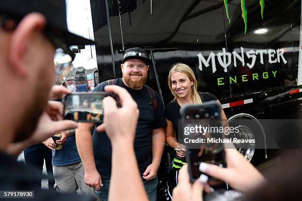 Fan Anthony Colletti gets his photo with driver Brittany Force during a rain delay at day one of the Mo-Par Mile High Nationals at Bandimere Speedway...