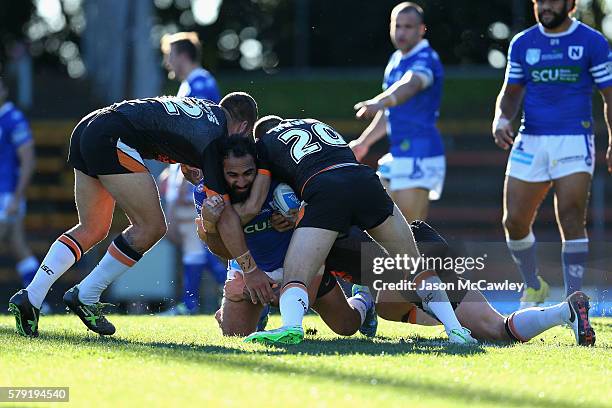 Travis Robinson of the Newtown Jets is tackled during the round 19 Intrust Super Premiership NSW match between the Wests Tigers and the Newtown Jets...