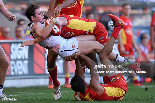 Lachie Neale of the Dockers is tackled during the round 18 AFL match between the Gold Coast Suns and the Fremantle Dockers at Metricon Stadium on...
