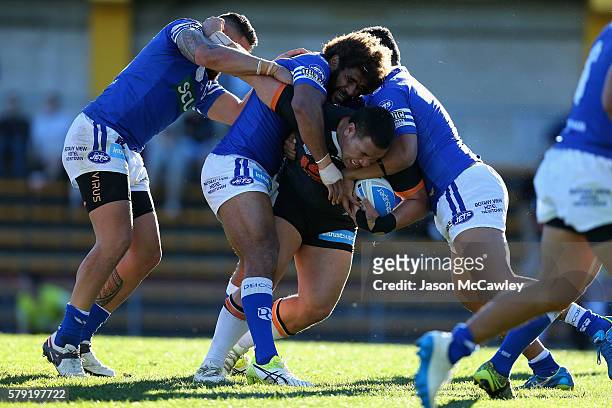 Wesley Lolo of the Wests Tigers is tackled by Vitale Roqica of the Newtown Jets during the round 19 Intrust Super Premiership NSW match between the...