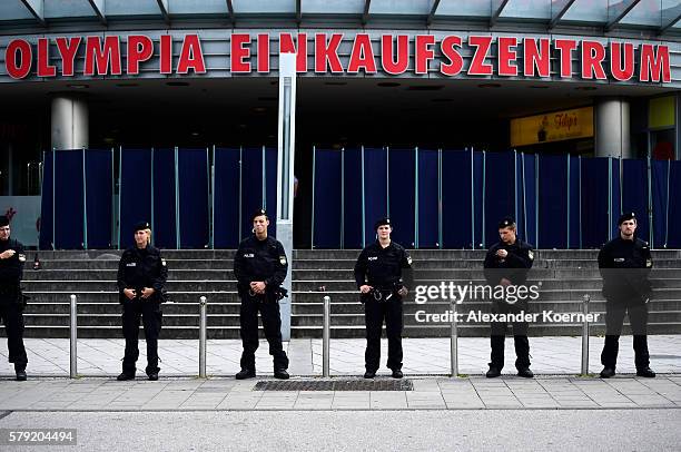 Police forces guard the crime scene outside the OEZ shopping center and the McDonalds the day after a shooting spree left nine victims dead on July...