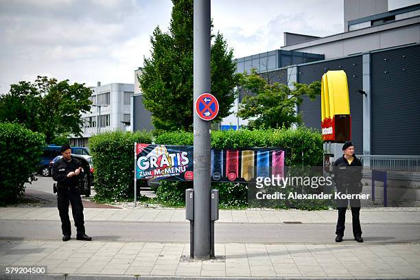 Police forces guard the crime scene outside the OEZ shopping center and the McDonalds the day after a shooting spree left nine victims dead on July...