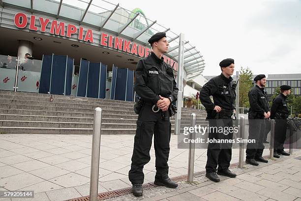 Police men guard the crime scene at OEZ shopping center the day after a shooting spree left nine victims dead on July 23, 2016 in Munich, Germany....