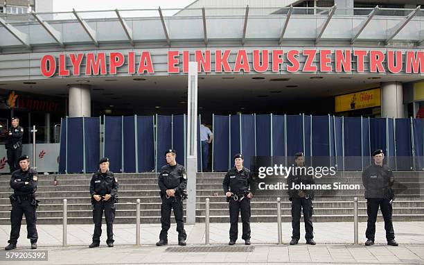 Police men guard the crime scene at OEZ shopping center the day after a shooting spree left nine victims dead on July 23, 2016 in Munich, Germany....