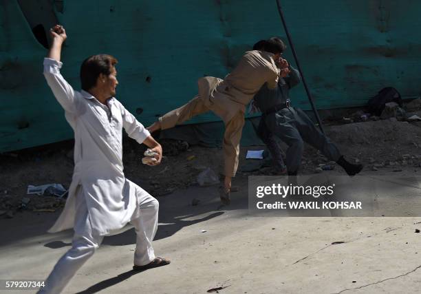 Afghan protesters beat a policeman after a suicide attack that targeted crowds of minority Shiite Hazaras during a demonstration at the Deh Mazang...