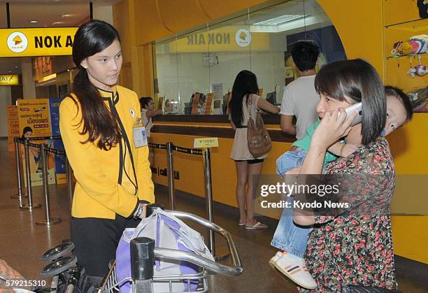 Thailand - An employee of Nok Air, a Thai budget airline, explains to passengers the airline has been forced to suspend operations for safety reasons...