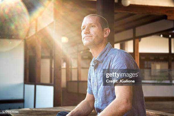 man sat looking thoughtful at a japanese temple - buddhism prayer stock pictures, royalty-free photos & images