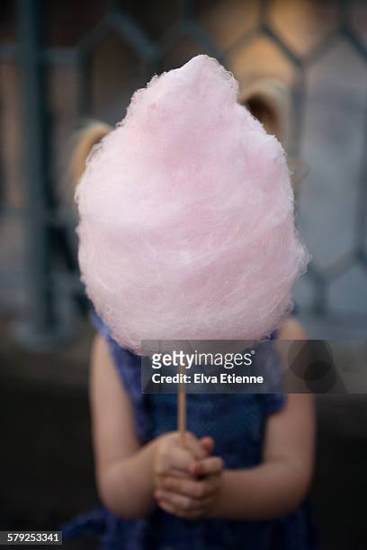 child holding pink candy floss in front of face - cotton candy stock pictures, royalty-free photos & images
