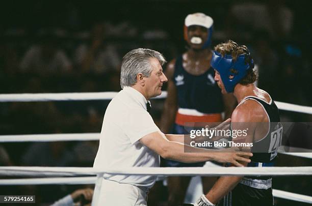 Referee Gligorije Novicic of Yugoslavia checks on Kevin Barry of New Zealand after he was knocked down by Evander Holyfield of the USA in the second...