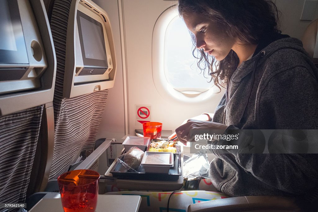 Woman eating lunch in airplane