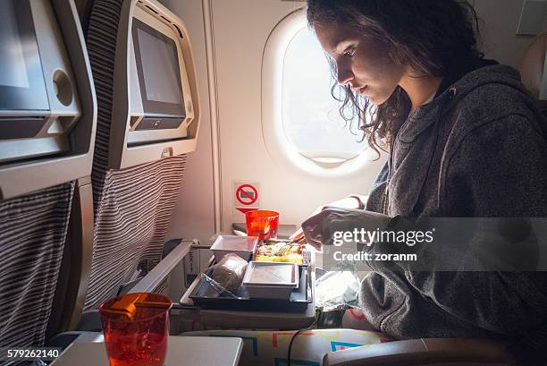 woman eating lunch in airplane - ekonomiklass bildbanksfoton och bilder