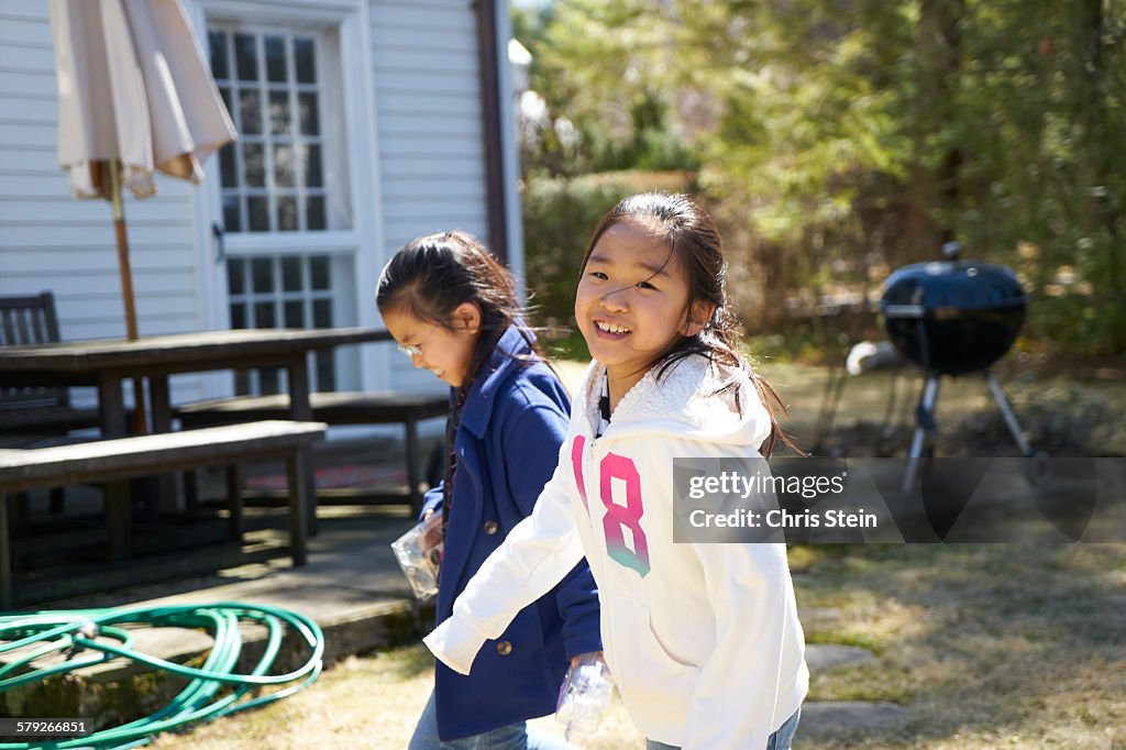 Asian twin girls  playing in the backyard