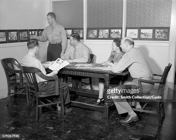 Here a number of CDC personnel analyze field data in order to formulate an epidemiologic plan of action, 1945. Photograph of a group discussion...