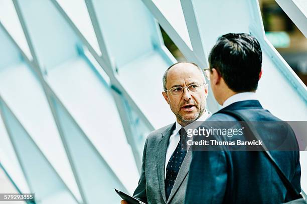 mature businessman in discussion with colleague - building dedication stock pictures, royalty-free photos & images