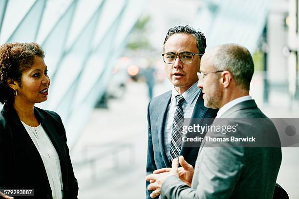 three colleagues in discussion in corridor - formal businesswear stock pictures, royalty-free photos & images