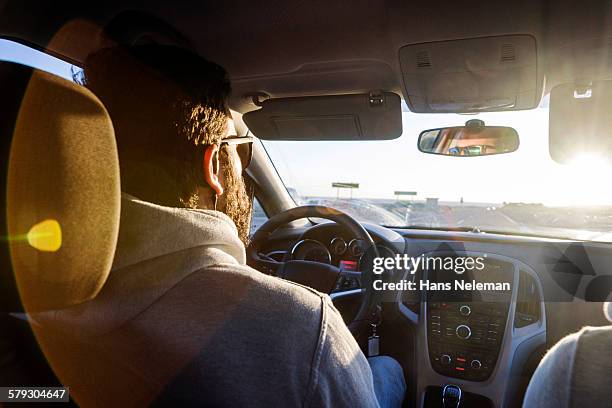 rear view of man driving a car - driver's seat stock-fotos und bilder
