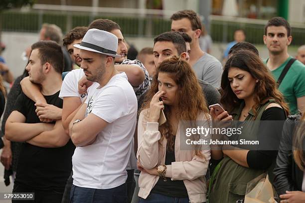 People mourn near the crime scene at OEZ shopping center the day after a shooting spree left nine victims dead on July 23, 2016 in Munich, Germany....