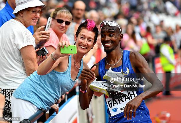 Mo Farah of Great Britain poses for pictures with fans after winning the Men's 5000m during Day Two of the Muller Anniversary Games at The Stadium -...