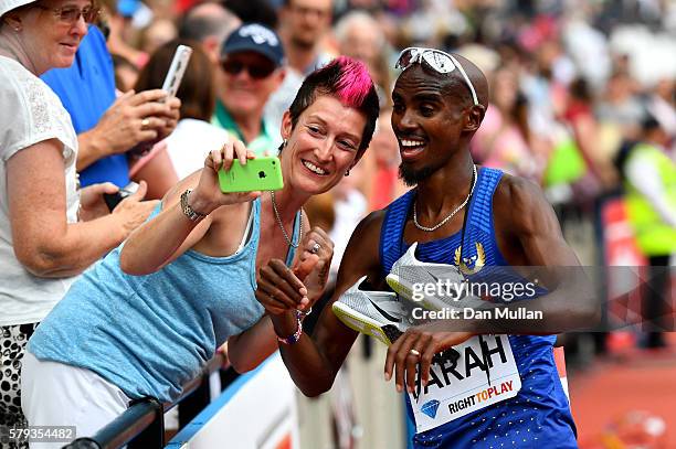 Mo Farah of Great Britain poses for pictures with fans after winning the Men's 5000m during Day Two of the Muller Anniversary Games at The Stadium -...