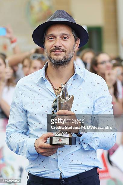 Claudio Santamaria poses with the Giffoni Experience Award during Giffoni Film Festival Day 9 blue carpet on July 23, 2016 in Giffoni Valle Piana,...